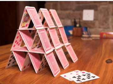 house-of-cards-on-a-wooden-table-picture-id95706155
